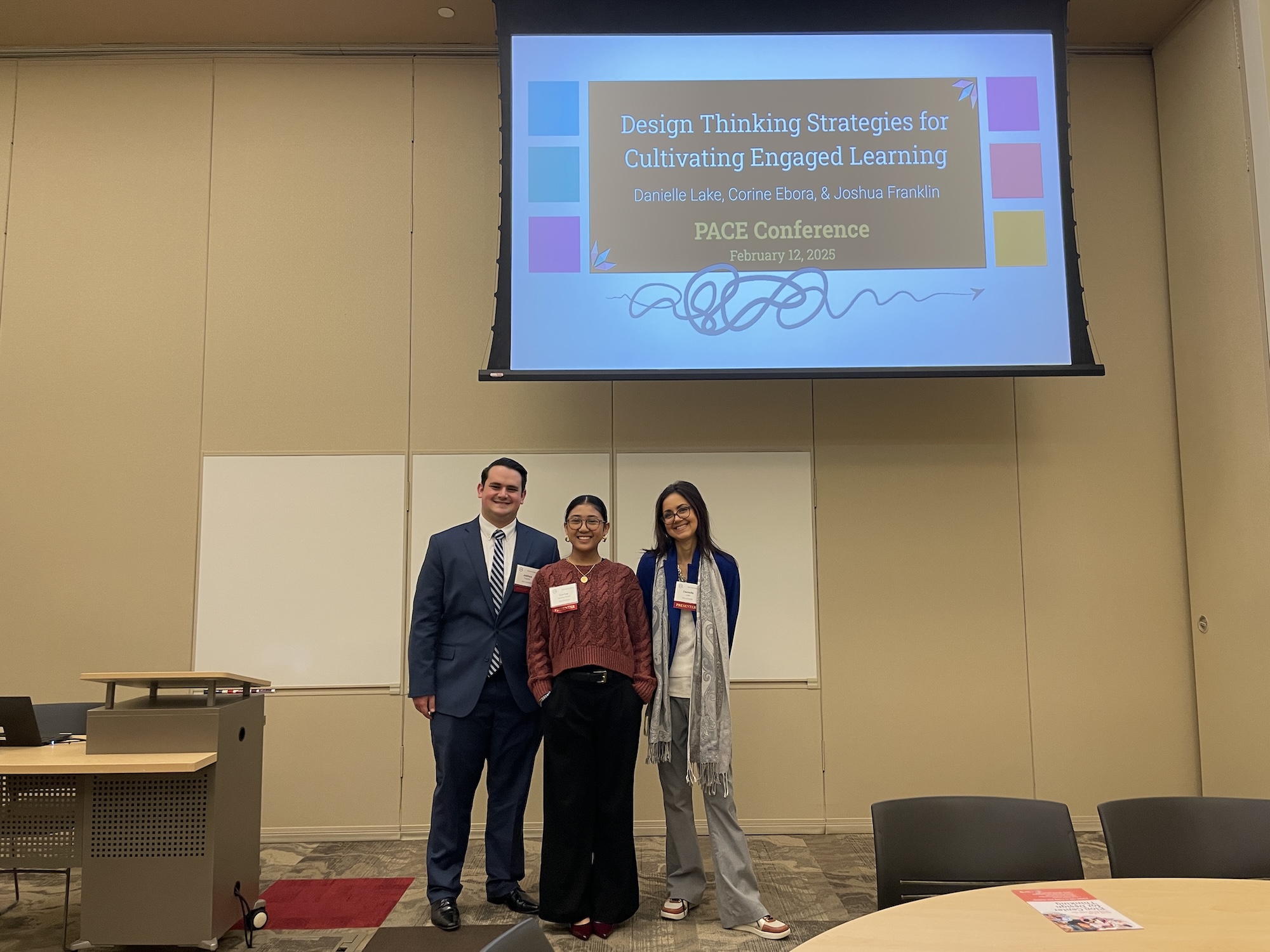 2 students and director of the center for design thinking danielle lake stand at the front of a classroom under a screen that shows the title slide for their conference presentation, Design Thinking Strategies for Cultivating Engaged Learning