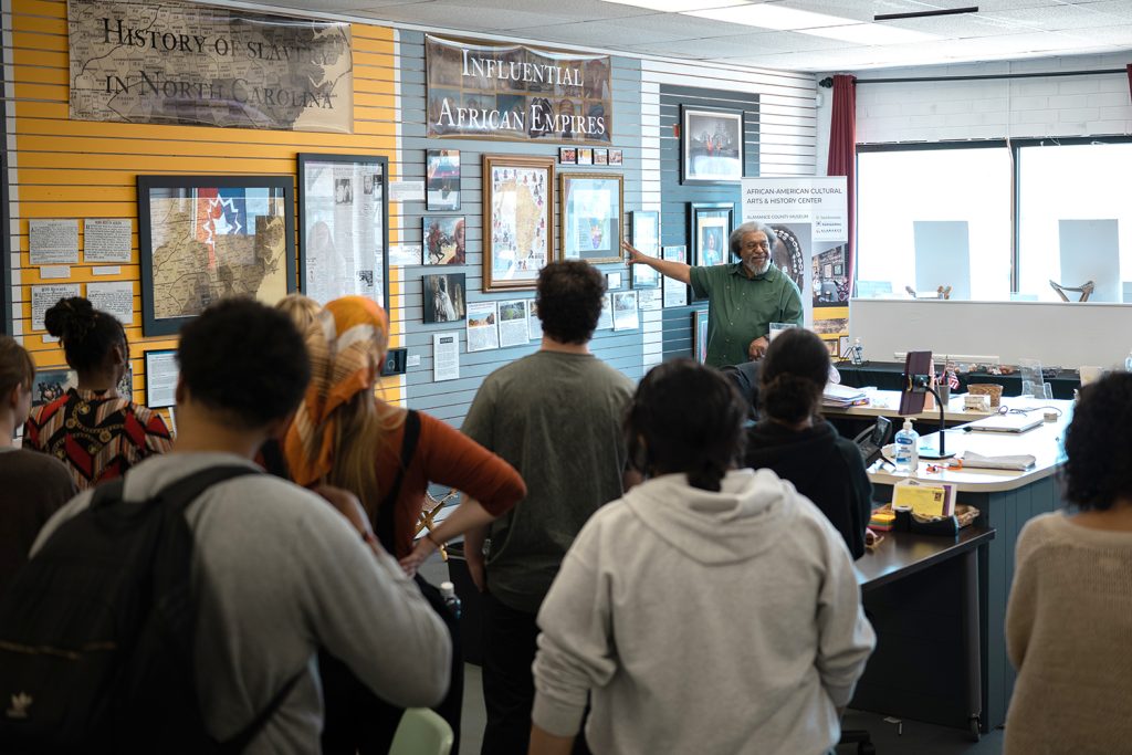 james shields talks to a human service studies class and points to an exhibit in the african american cultural arts and history center