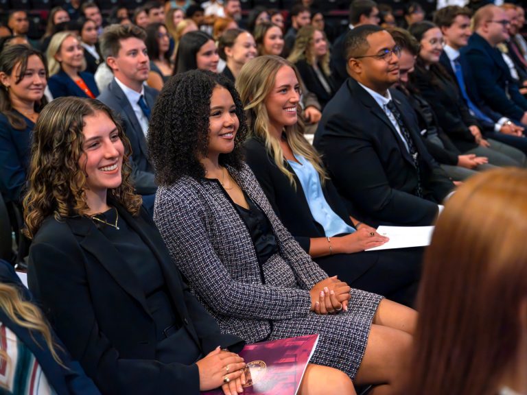 incoming students at elon school of law sit in rows and smile during new student convocation