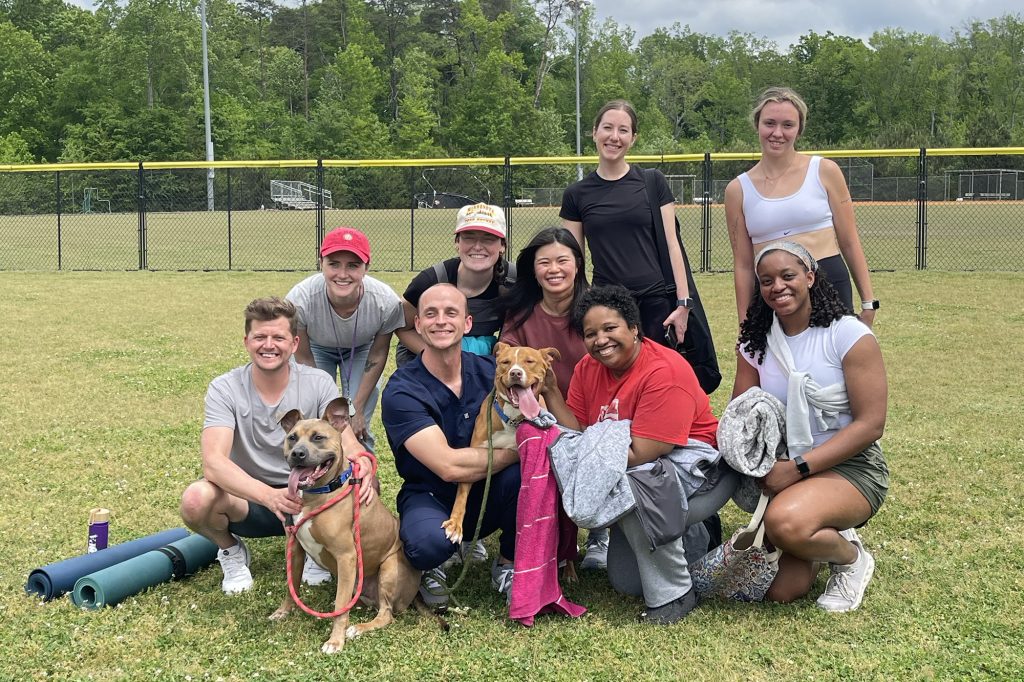 Students pose with their puppy yoga partners