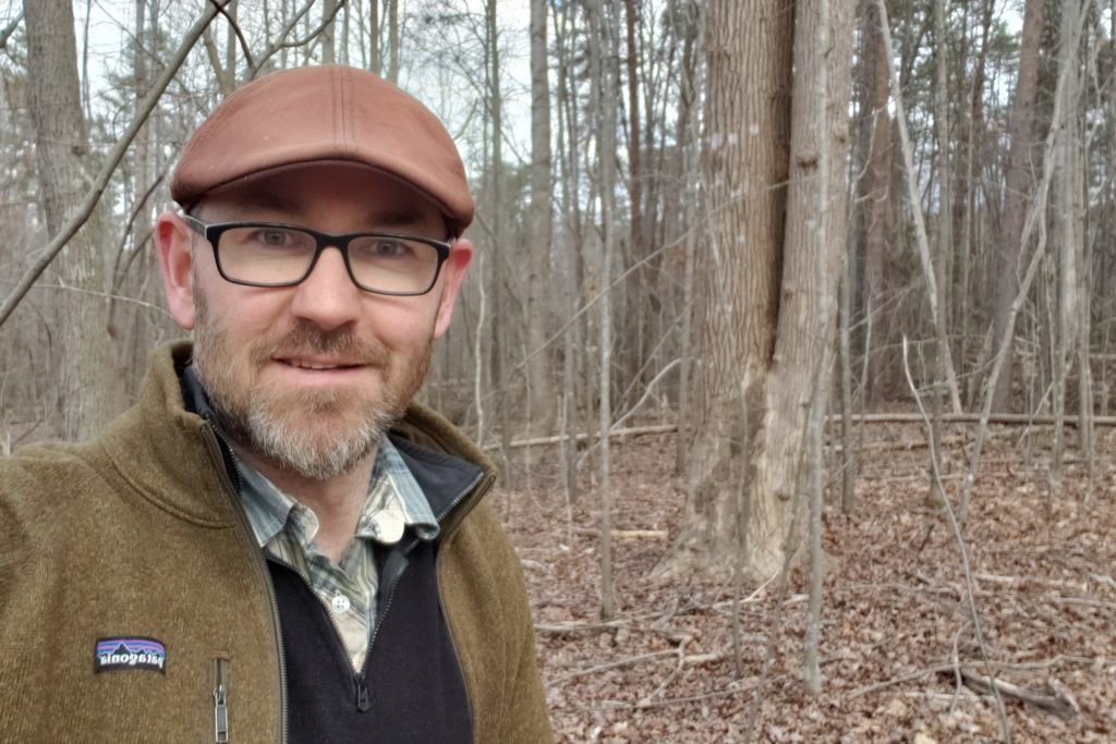 of Environmental Studies and Geography Ryan Kirk standing in Elon Forest