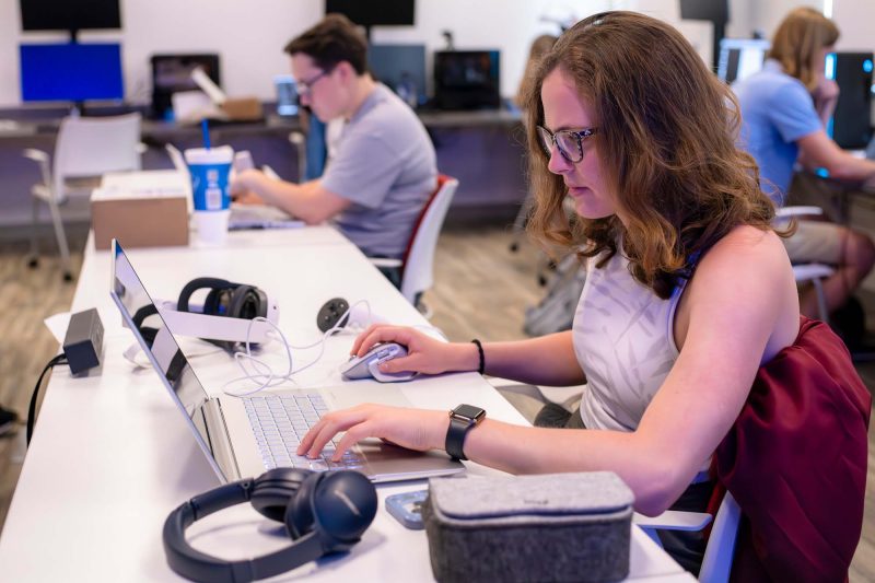 Students sit at computers