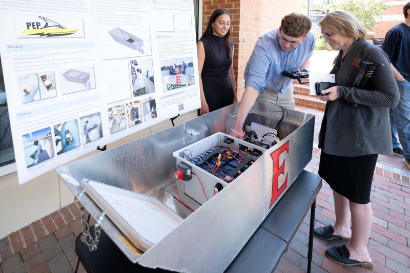 Students demonstrate large device as part of research project presentation
