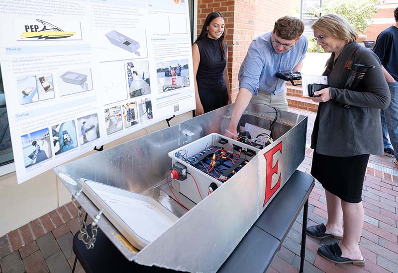 Students demonstrate large device as part of research project presentation