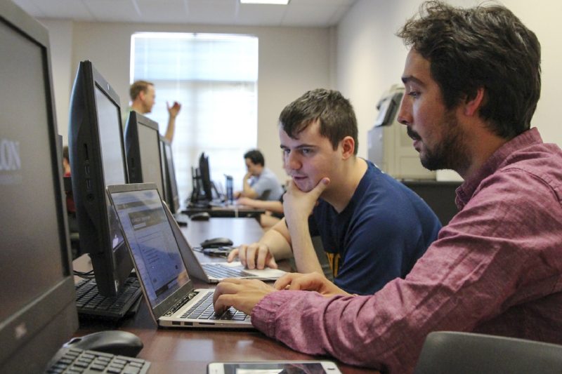 Two students working at laptops in a computer lab. Explore a bs computer science at Elon University.