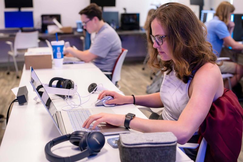 Students sit at computers in a lab