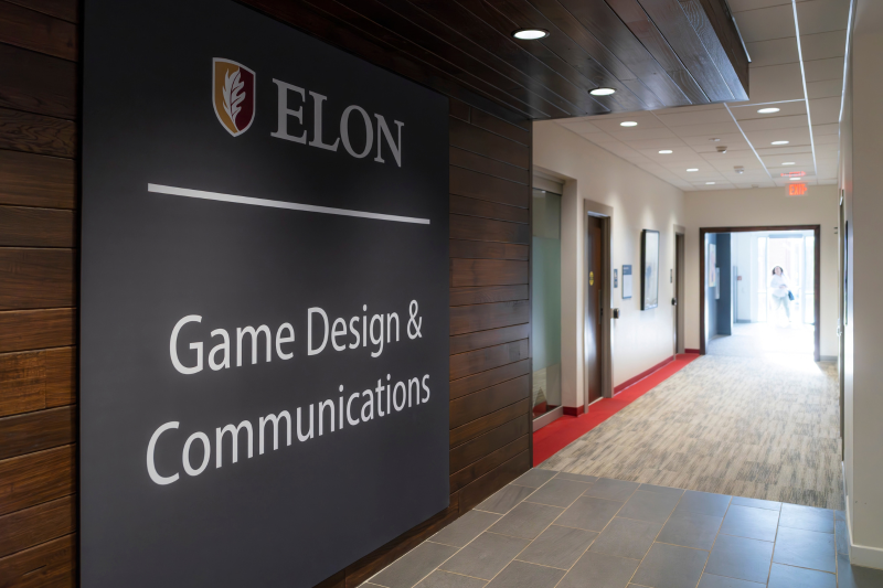 Hallway with large sign: Elon Game Design & Communications