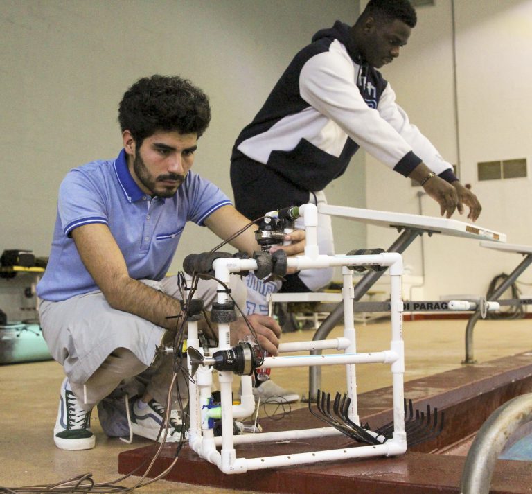 A student examines his ROV before testing