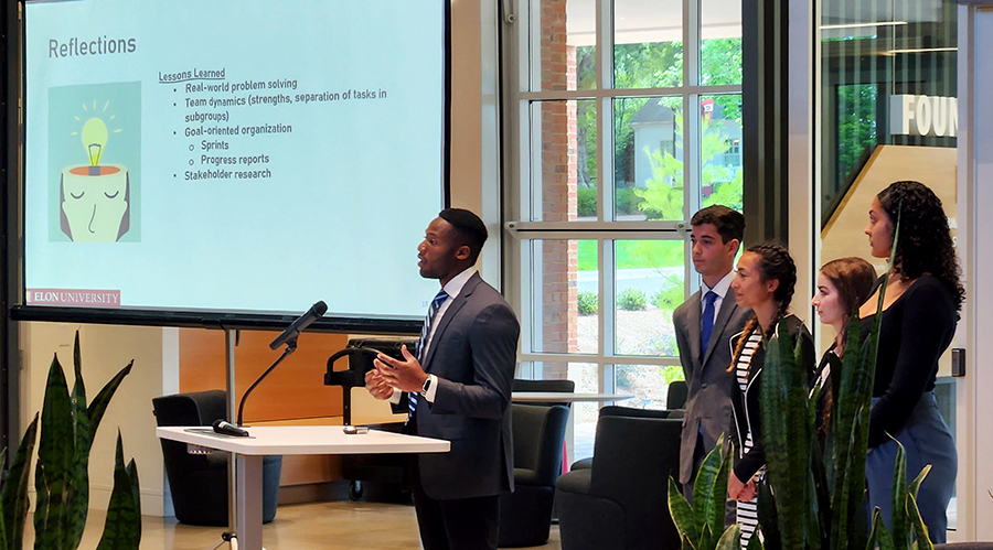 a team of five students present their end-of-year projects in Founders Hall