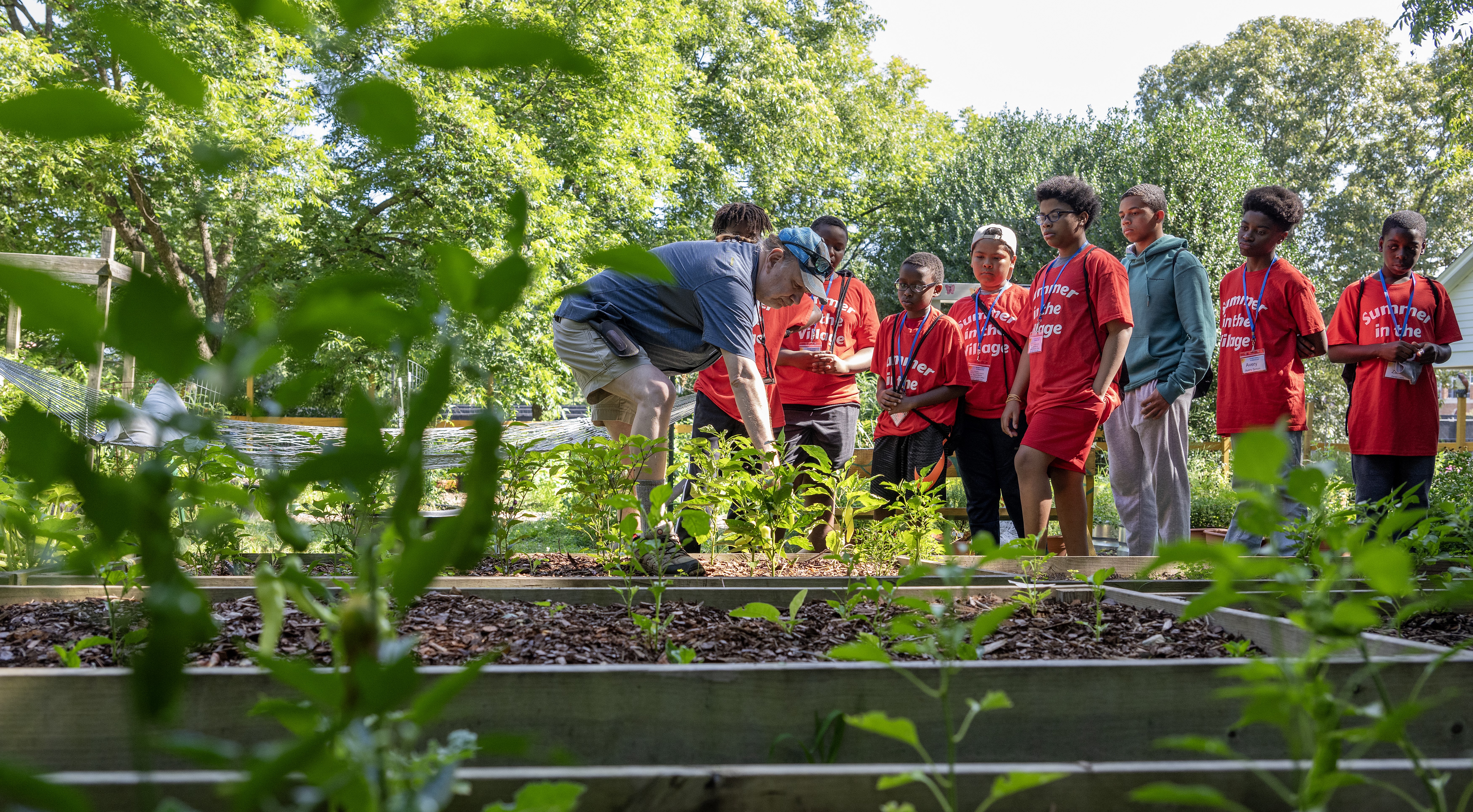 A professor shows elementary school students Elon's community garden. Explore environmental sciences and sustainability at Elon.