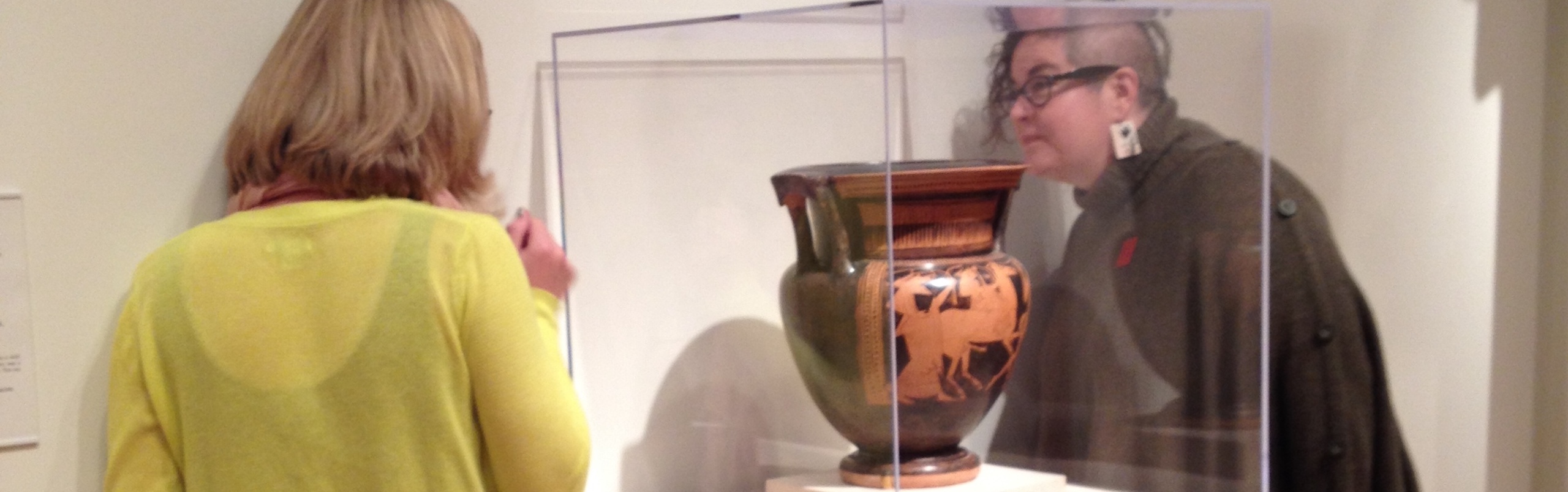 two people looking at a Greek vase