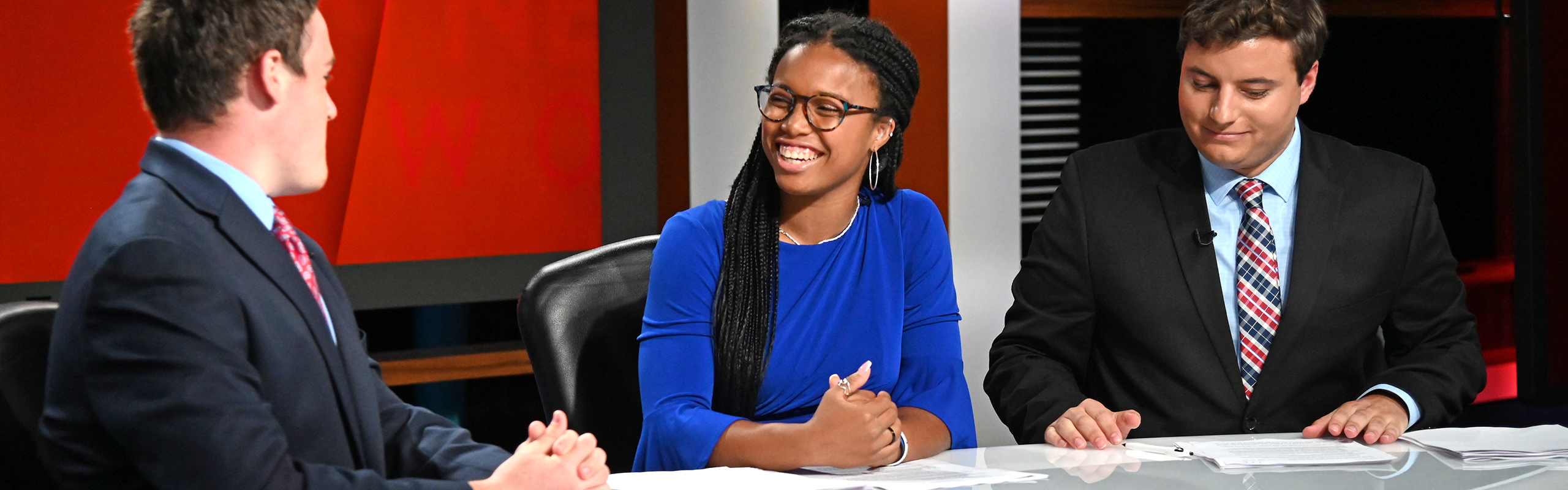 Franklin, who earned a degree in journalism, smiles while at an anchor desk.