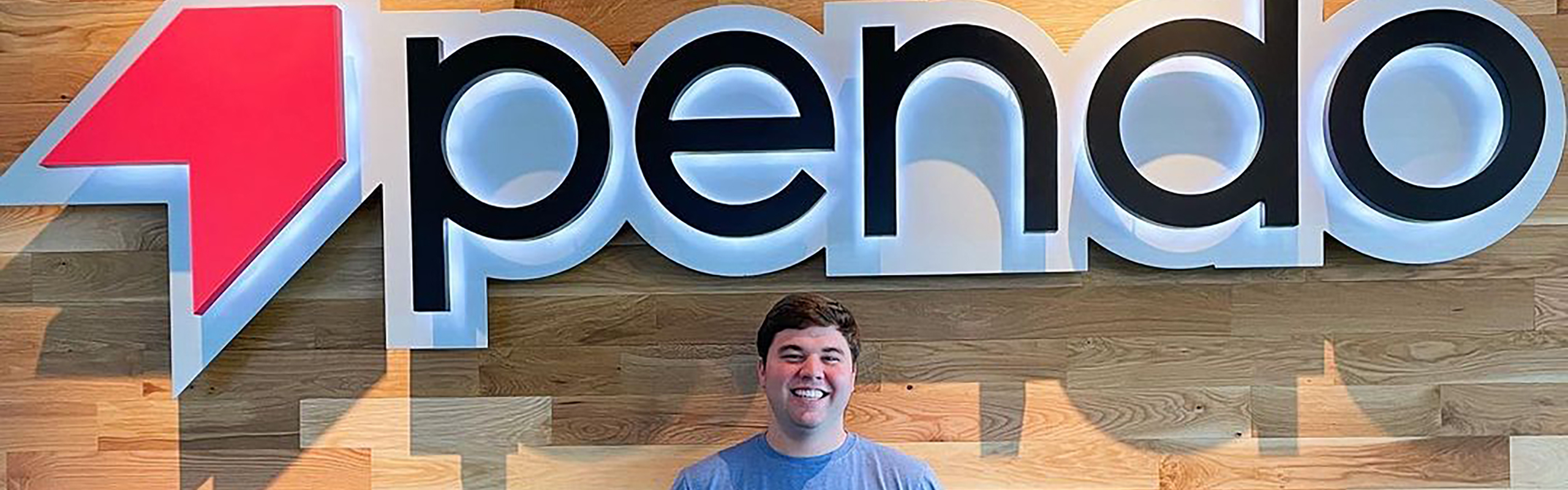 Matt Newberry stands in front of a Pendo sign.