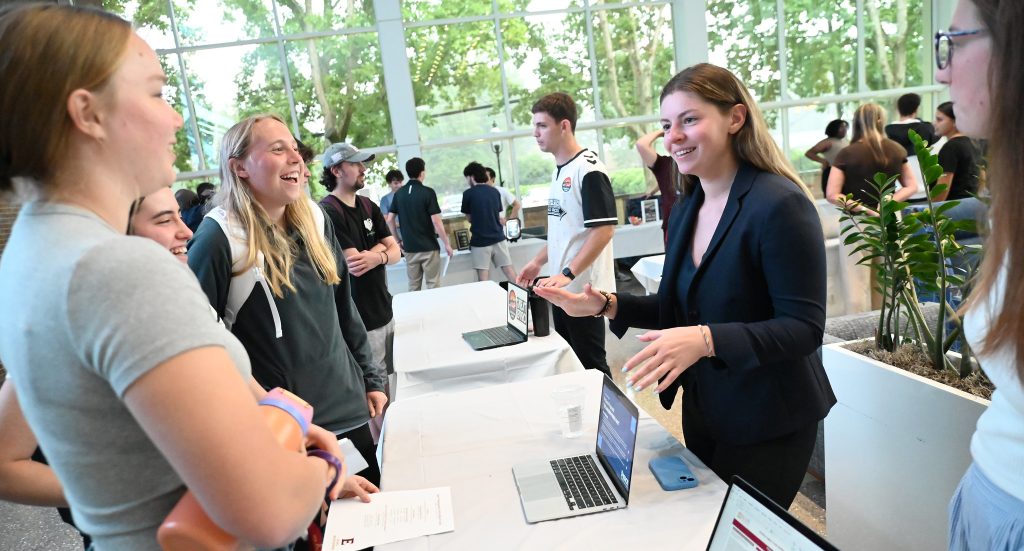 An Elon student talks to other students.