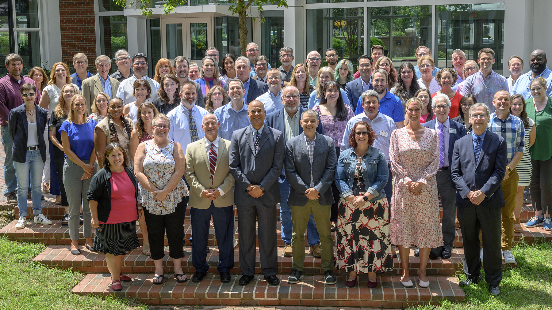 A group of teachers standing in a group on outside brick stairs.