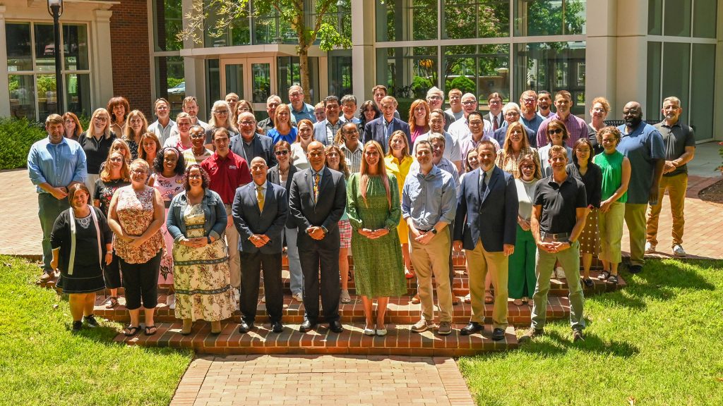 A group of ������Ƶ School of Communications educators standing in a group Under the Oaks.