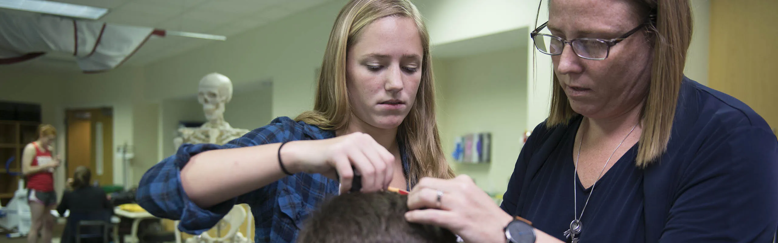 A student and professor prepare a participant for a research study