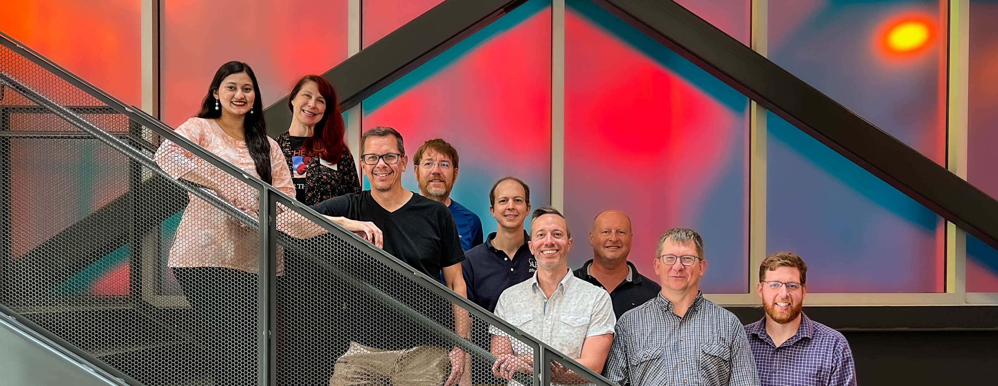 Nine physics department faculty members on the stairs in Innovation Hall
