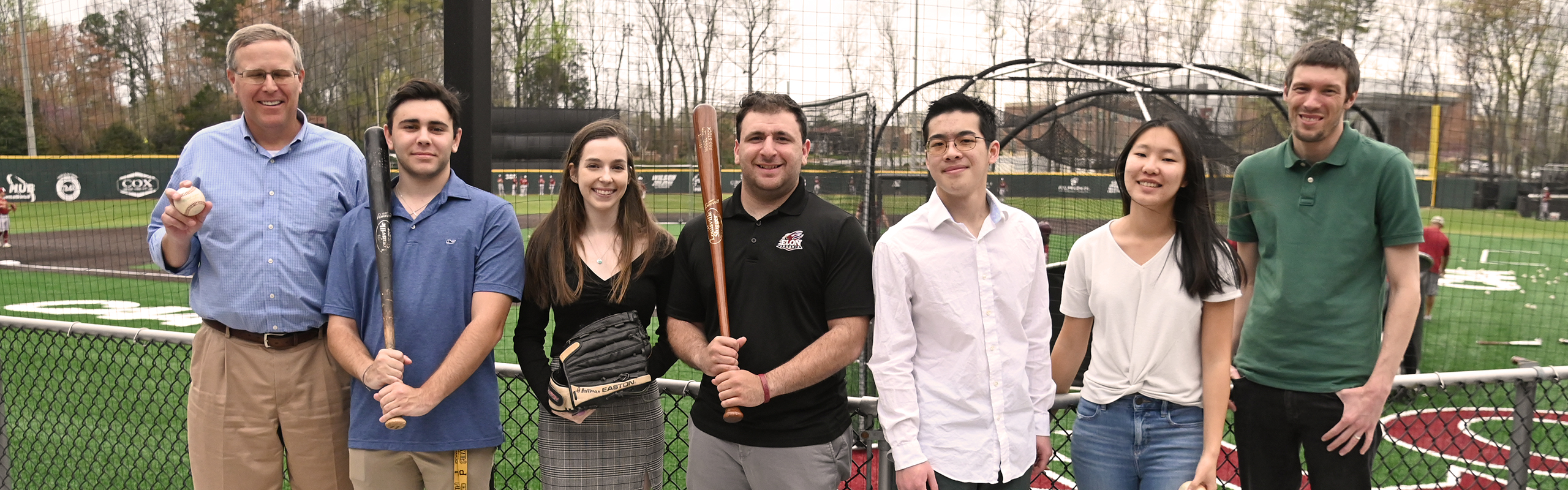 A group of Elon University students pose with baseball gear following a successful entry in the SABR case competition.
