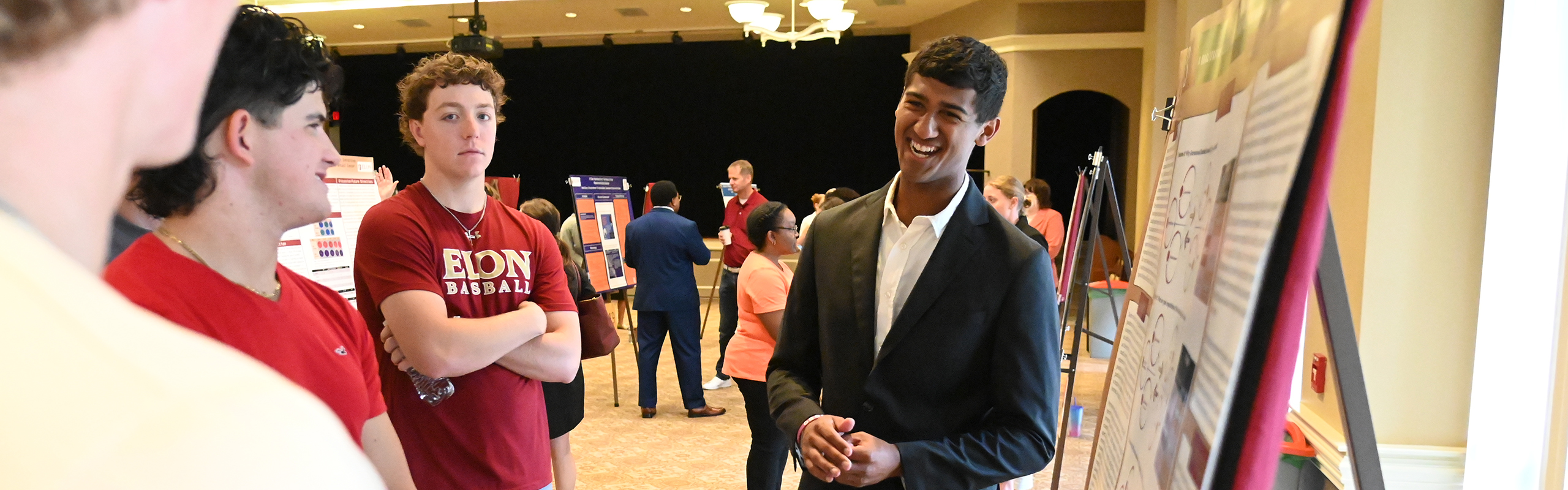 A sport management major smiles while presenting research during the SURE program to a group of sport management majors.