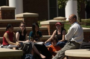 Picture of students and faculty sitting outside on campus