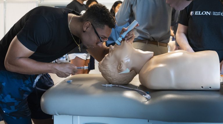 Physician Assistant student Mauricio Vazquez practices intubation on a mannequin.