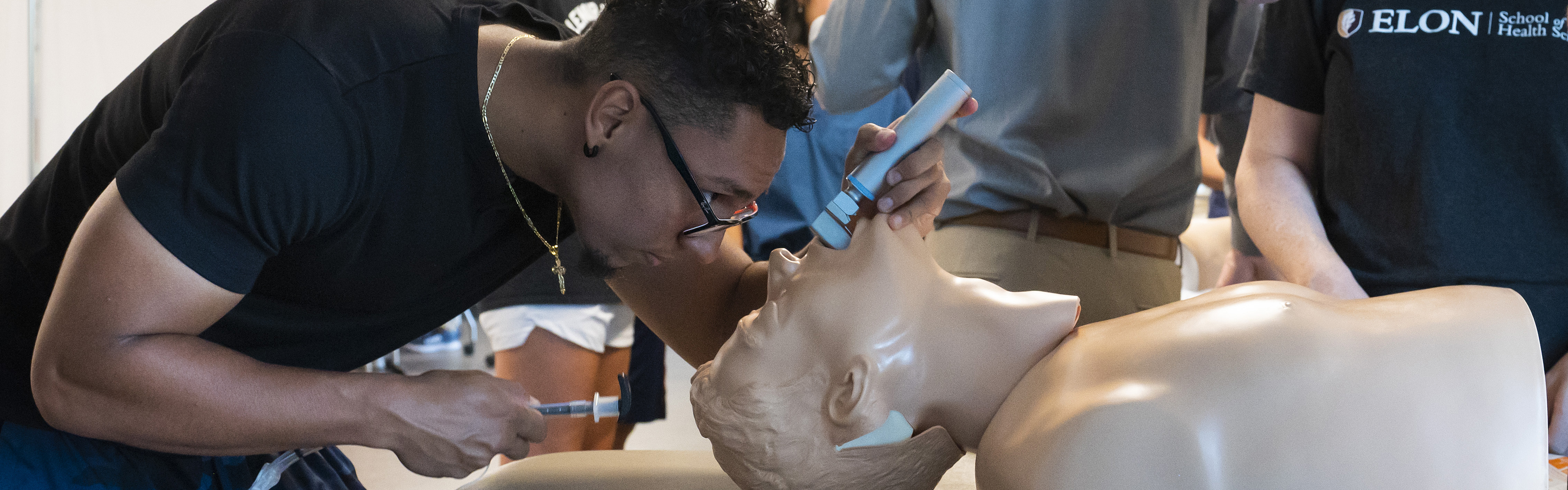 Physician Assistant student Mauricio Vazquez practices intubation on a mannequin.