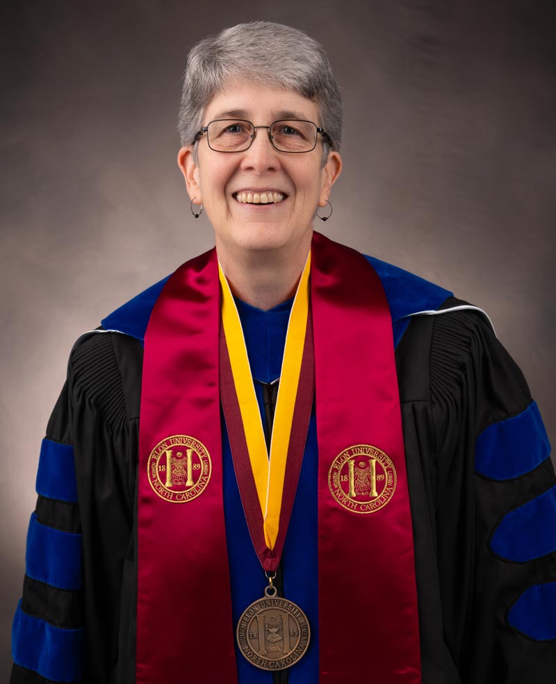 Distinguished University Professor Mary Jo Festle in regalia with stole and Elon University medallion.