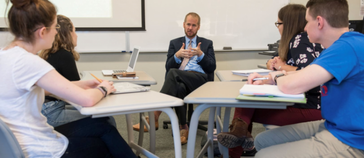 Professor Jeffrey Carpenter talking with students in the classroom.