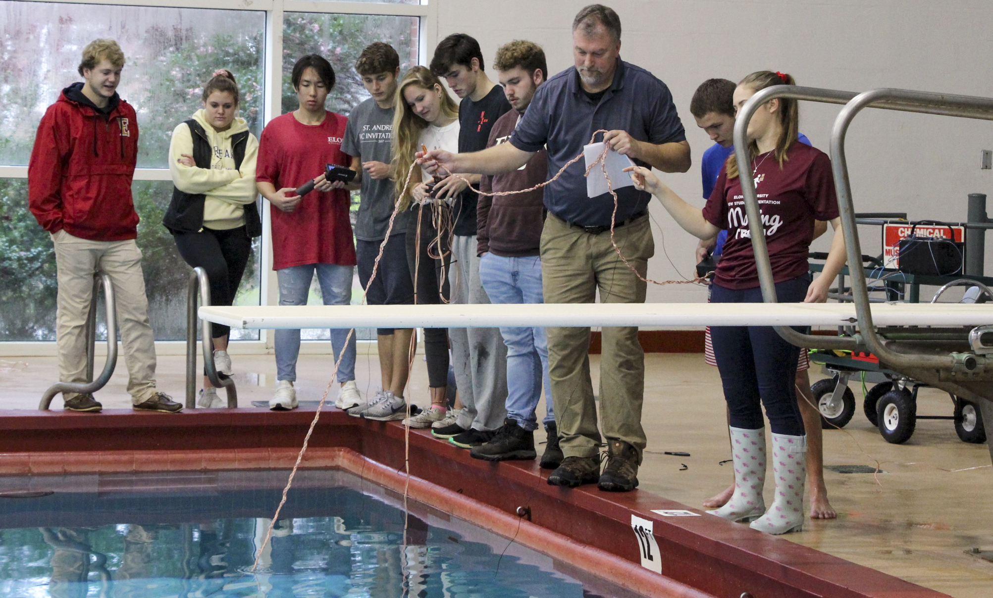 Scott Wolter assists the Grand Challenges in Engineering I class in testing their underwater vehicle designs inside Koury Gym in December 2019.