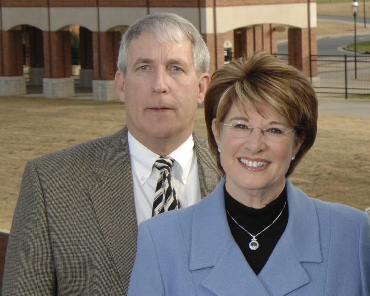 Two people in business attire pose for a photo