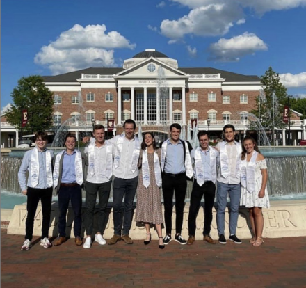 Nine students standing in front of a building