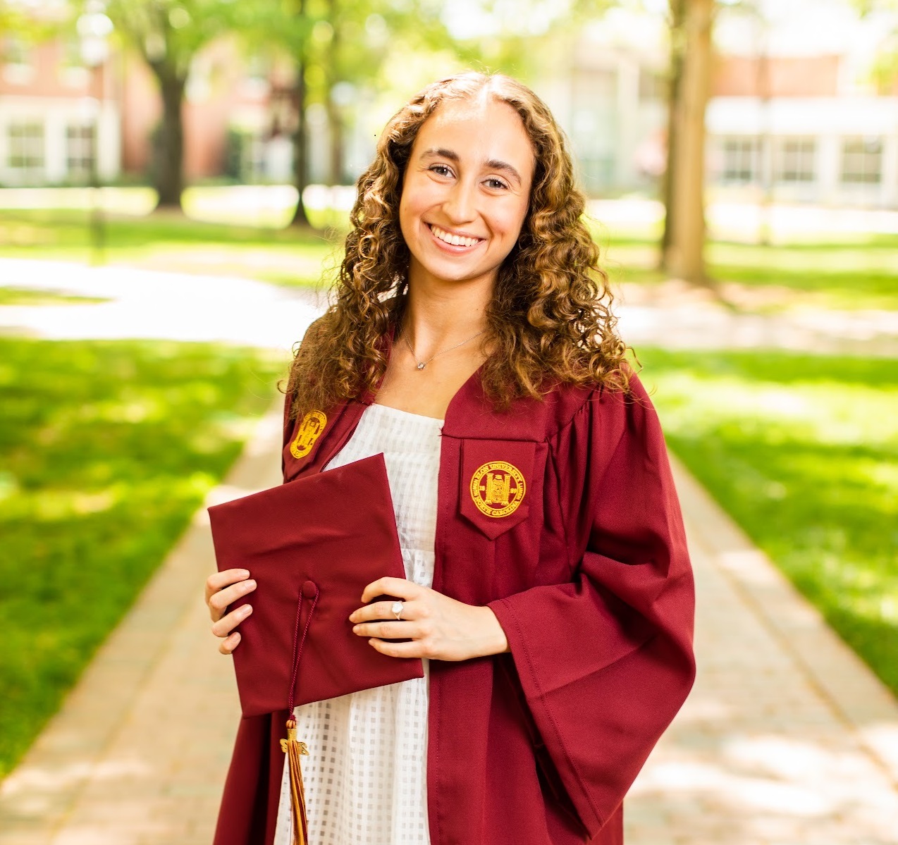 Alexandra Strouse '22 in maroon cap and gown on Elon's campus.