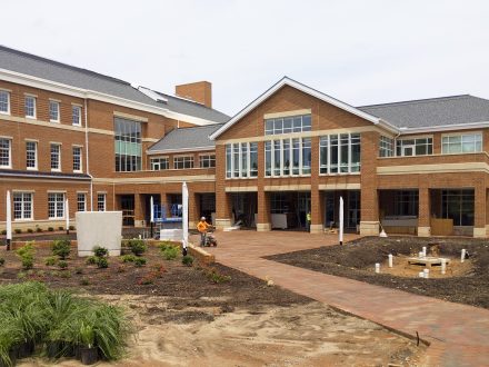 Crews prepare landscaping by planting flowers and shrubs and pressure washing walkways leading to Founders Hall and Innovation Hall.