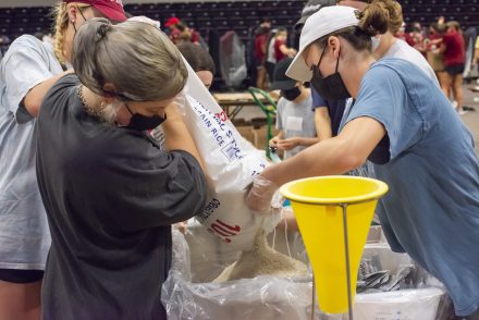Students filling up bags of rice to be included in packaged meals