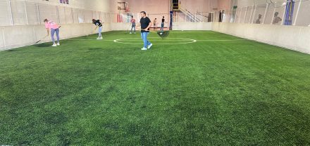 Students cleaning indoor soccer field