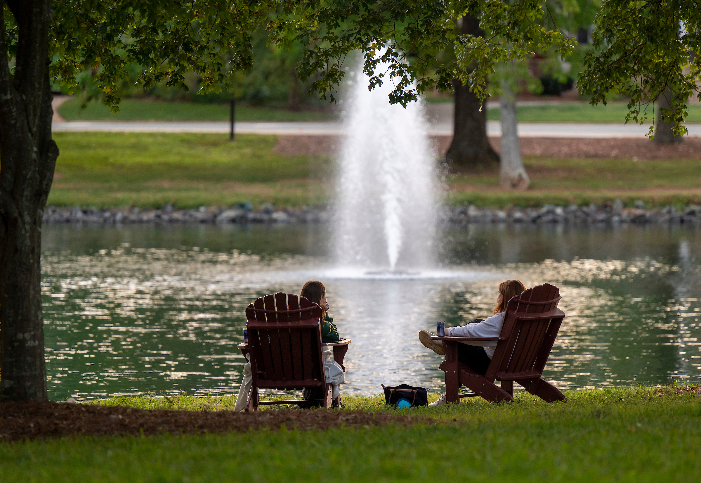 People sitting by Lake Mary Nell watching the fountain.