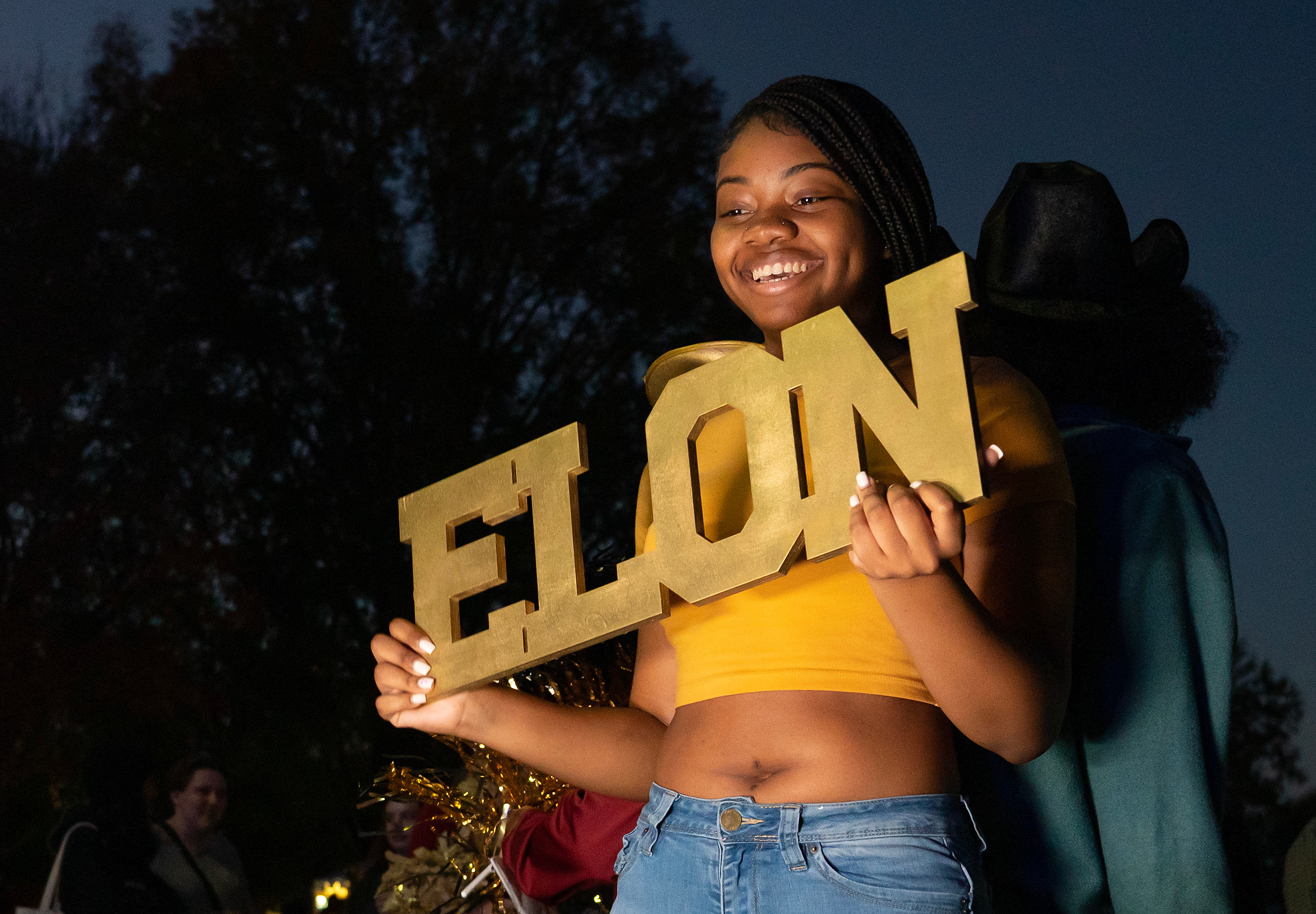 Smiling woman holding "Elon" sign