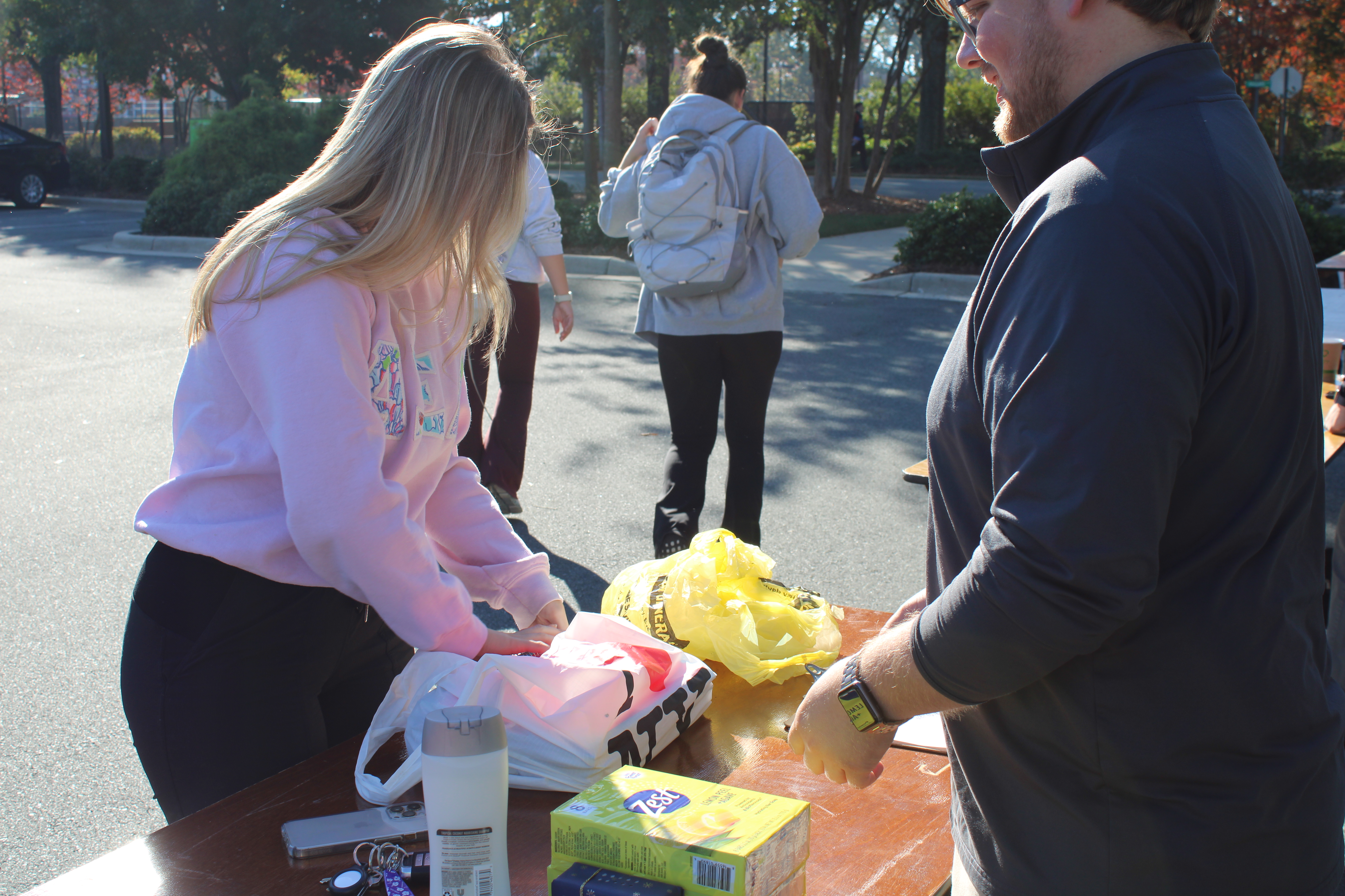 A student donating supplies for the school supplies and hygiene drive during Greek and Service Week.
