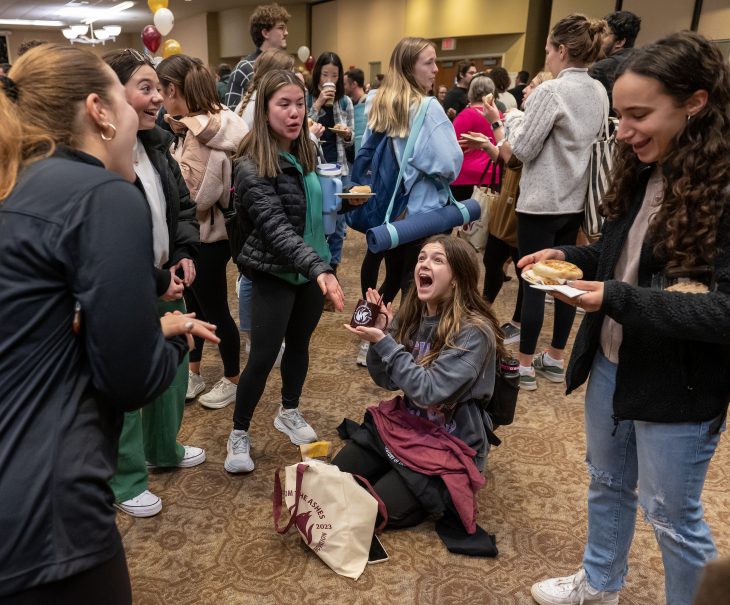 Henna Reid ’24, celebrates with friends as she discovers a mug in a bag she won in a raffle at College Coffee, held January 31, 2023, in McKinnon Hall on the campus of Elon University.