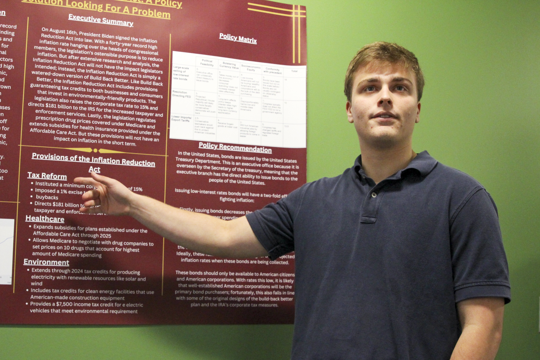 Curran Gilster gestures to a research poster