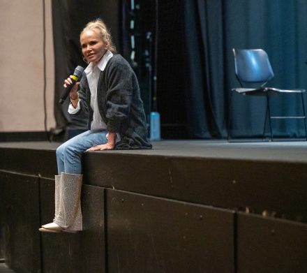Kristin Chenoweth sitting on the edge of the McCrary Theatre stage.