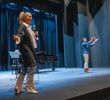 Actress Kristin Chenoweth onstage with student performing.