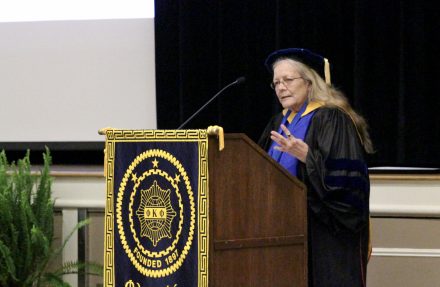 Nancy Harris speaks at a podium McKinnon Hall