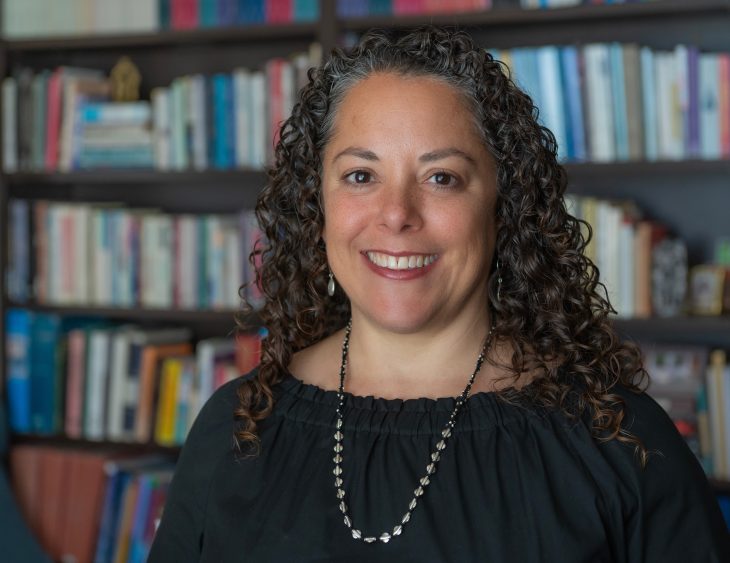 Amy Allocco in front of a wall of books