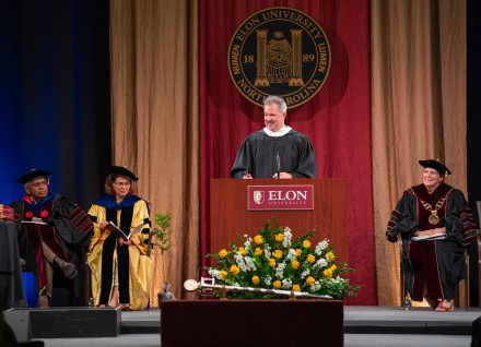 David Young speaks behind the podium on the Commencement stage