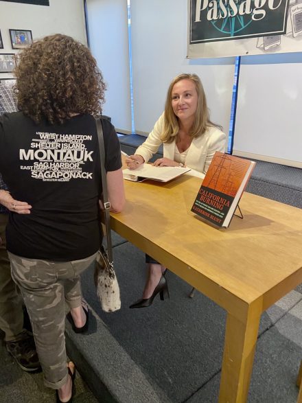 Katherine Blunt signing a copy of her book and talking to a fan.