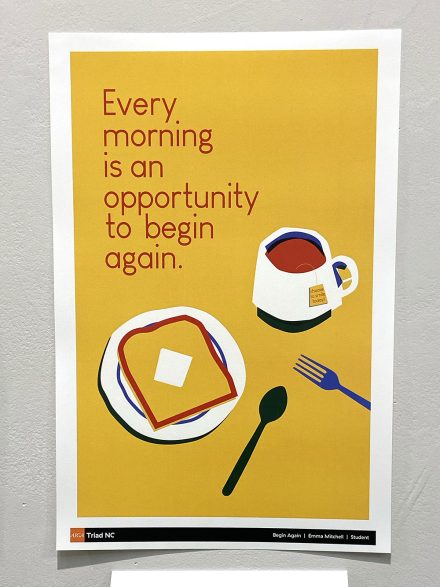 A yellow poster hangs on a white wall depicting a breakfast of toast and coffee.