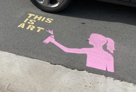 An image of graffiti art on the pavement showing a silhouette of a girl