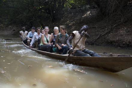 Students and villagers in a canoe on a river in Ghana